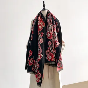 Detail of ethnic paisley floral pattern on black scarf with delicate fringe edges