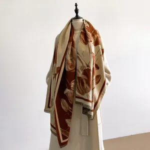 Close-up of beige and caramel floral scarf with soft fringes and cashmere-like texture