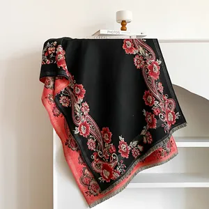 Macro view of detailed vintage paisley floral pattern and fringe on black cashmere-like scarf