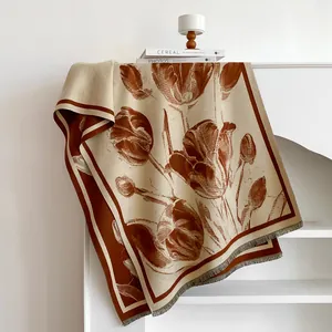 Detail of red tulip pattern and tassel edges on soft off-white cashmere feel scarf