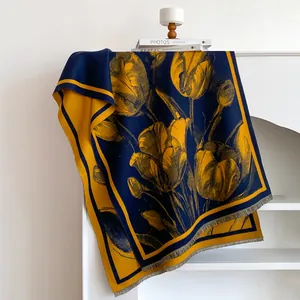 Close-up of tulip floral pattern on a thick blue and yellow cashmere-feel winter scarf