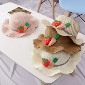 Detailansicht von Strohhüten mit Wellenrand und Erdbeerdeko in vier verschiedenen Farben