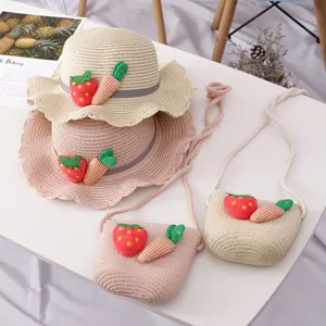 Detail von Strohhüten mit Wellenrand und Taschen mit Erdbeer- und Karottenanhängern