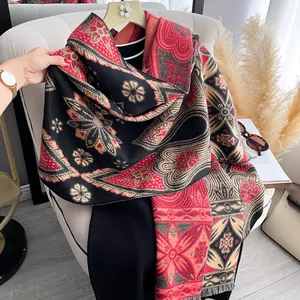Detail eines rot-schwarzen Kaschmir-ähnlichen Schals mit feinen Quasten und Paisley-Muster