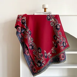 Macro shot of red paisley floral pattern on warm cashmere-like shawl with fringed edges
