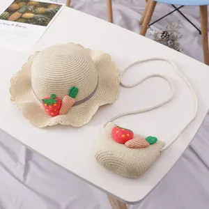 Detailansicht von Kinderstrohhut und Tasche mit Erdbeer- und Karottenmotiven