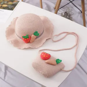Detail von rosa Strohhut und Tasche mit süßen Erdbeer- und Karotten-Aufnähern