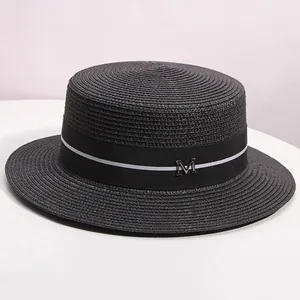Detail of black boater hat with striped ribbon and metallic M letter buckle