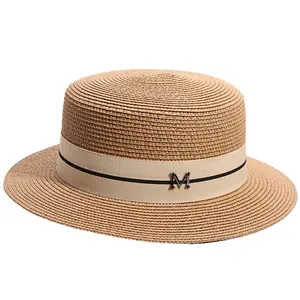 Flat top straw boater hat with beige ribbon and metal M letter for summer beach vacations