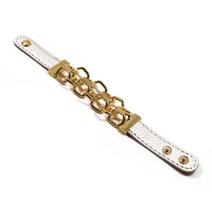 Dettaglio del cinturino in pelle bianca martellata con maglie metalliche dorate intrecciate