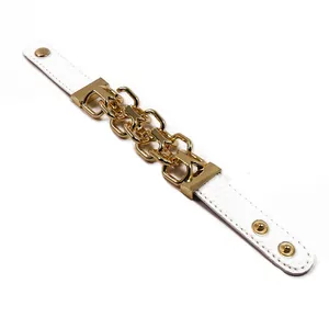 Dettaglio del bracciale in pelle PU bianca punk con catene in oro e bottoni a pressione