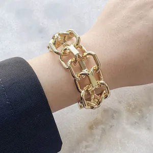 Bracciale a catena a maglie rettangolari dorate in stile punk su superficie strutturata