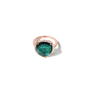 Makroaufnahme des birnenförmigen grünen Kristallrings mit Halo-Fassung in Roségold