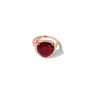 Makroaufnahme eines roségoldenen Rings mit geometrischem rotem Herzstein und Diamantkranz