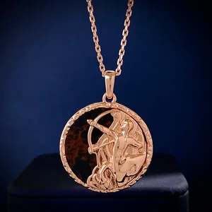 Macro view of Sagittarius zodiac coin pendant with rose gold relief on black marble
