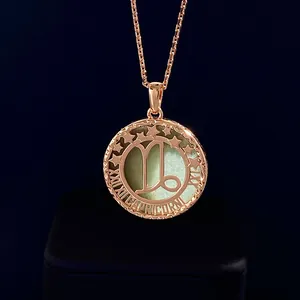 Macro detail of Capricorn rose gold pendant with green semi-precious stone and star engraving