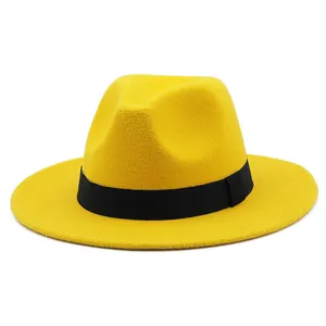 Macro detail of yellow wool felt fedora with a contrasting black ribbon band
