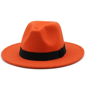 Close-up of a bright orange wool felt fedora featuring a wide black grosgrain ribbon band