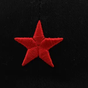 Gros plan détaillé d'une broderie d'étoile rouge à cinq branches sur une casquette noire