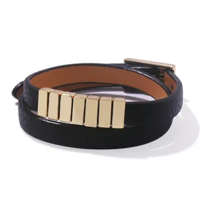Detail of double-wrap black lizard-embossed leather bracelet with gold metal accents