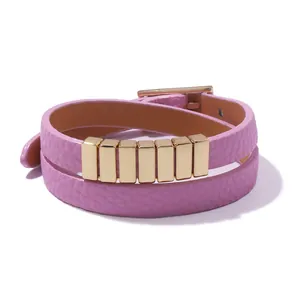 Detail view of pink double-wrap leather bracelet with polished gold metal accents and buckle