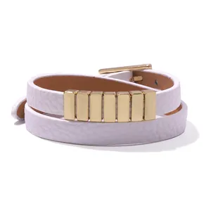 Detail of white double-wrap faux leather bracelet with six gold metal studs and buckle