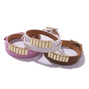 Detail of leather wrap bracelets in pink white and brown with gold metal squares