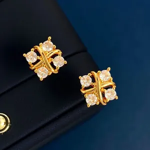Λήψη macro από επίχρυσα σκουλαρίκια σταυρός 18K με τέσσερα ζιργκόν σε δέρμα