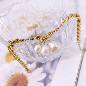 Dettaglio catena oro 18K con perle barocche su bordo di ciotola in cristallo