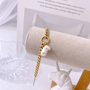 Dettaglio macro del bracciale a catena in oro 18K con ciondolo a perla barocca