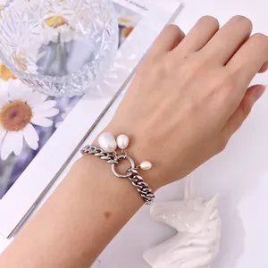 Dettaglio del bracciale a catena groumette d'argento con perle barocche indossato da una modella