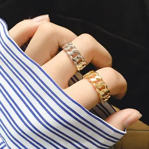 Retro Cuban link twist open rings in polished gold and silver finishes on model