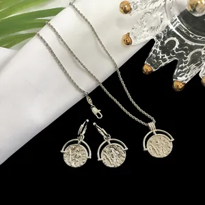Detail of silver-toned Roman coin jewelry set with embossed coin pendant and matching earrings