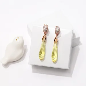 Detail von Roségold-Ohrhängern mit gelben Kristallen und Pavé-Diamanten Besatz