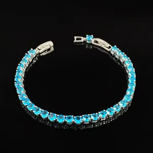Detailed view of tennis bracelet featuring round blue cubic zirconia in silver setting