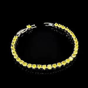 Macro shot of silver-tone tennis bracelet featuring round brilliant yellow cubic zirconia