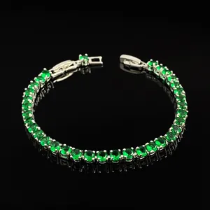 Detailed view of silver tennis bracelet with green round-cut cubic zirconia and claw setting