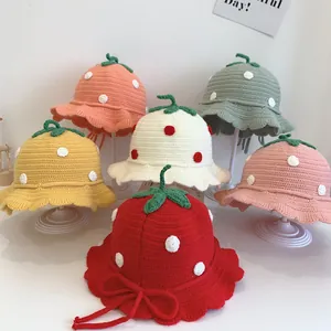 Detail view of colorful knitted strawberry hats for toddlers with cute wavy brims