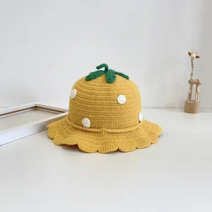 Cozy yellow knitted kids sun hat with white polka dots and green leaf decor