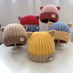 Detailansicht der gestrickten Babymützen mit Katzenohren und Löwenaufnähern