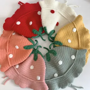 Top view of handmade strawberry knit hats in six vibrant colors with crochet leaf details