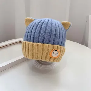 Niedliche Baby-Strickmütze mit Löwen-Patch, blau-gelbem Patchwork und kleinen Ohren
