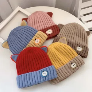 Detailaufnahme von gerippten Baby-Strickmützen mit Tierohren und Löwen-Aufnähern