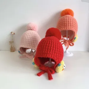 Tre cappelli lavorati a maglia per neonati con paraorecchie rosa e rossi e fodera in pile