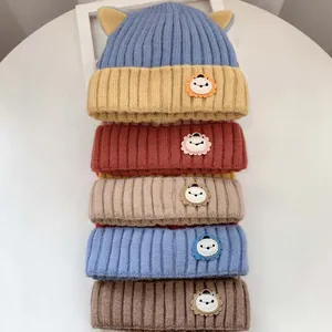 Detailaufnahme von Baby-Strickmützen mit süßen Löwen-Aufnähern in verschiedenen Farben