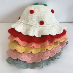 Detail of stacked knitted hats for kids showing wavy brim textures and varied colors