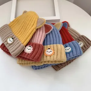 Detail von gerippten Baby-Strickmützen mit süßen 3D-Ohren und Cartoon-Löwen-Aufnähern