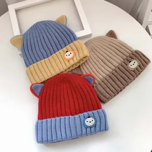 Detail von Strickmützen für Babys mit Katzenohren und Löwen-Aufnähern in Farben