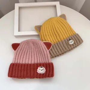Detailaufnahme von gestrickten Babymützen mit Löwenabzeichen und Tierohren-Design