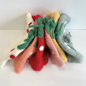 Detailed view of hand-knitted baby strawberry beanies in six vibrant colors and soft yarn